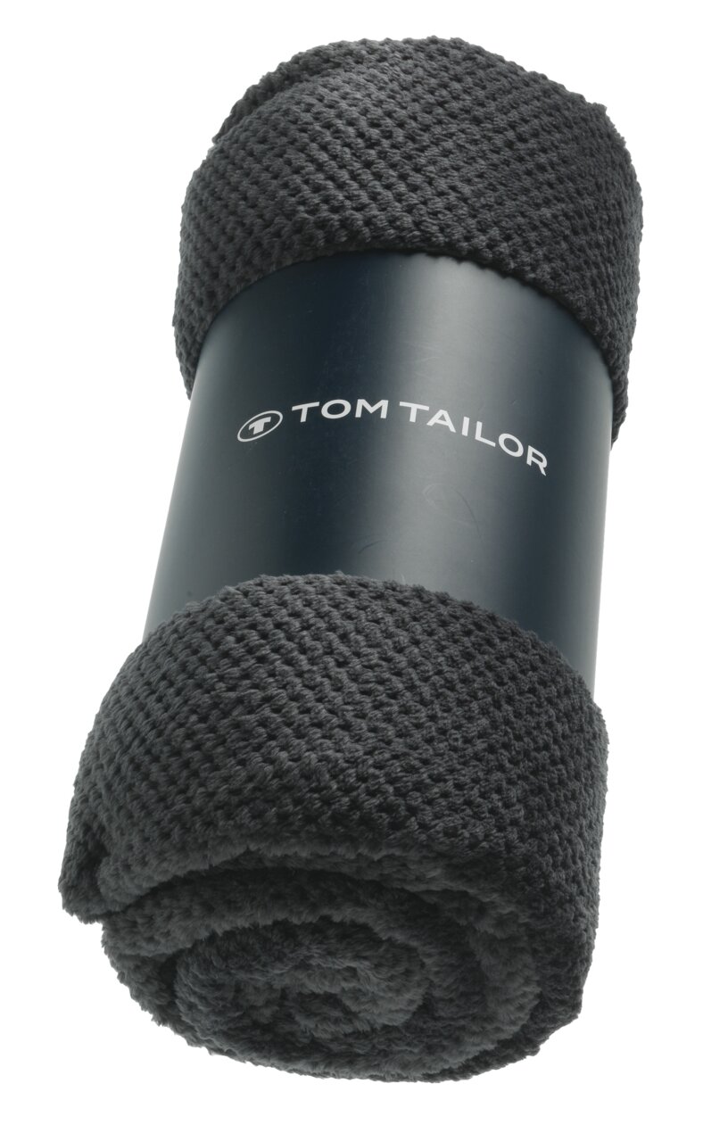 Dunkelgraues Plaid von Tom Tailor, zusammengerollt und von vorne fotografiert.
