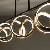 Moderne Deckenleuchte mit goldenen, ineinander verschlungenen Ringen, seitliche Perspektive