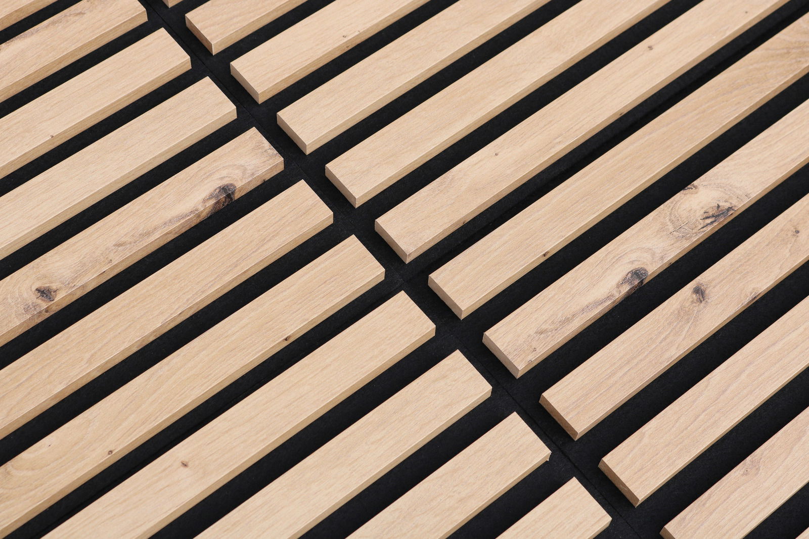 Nahaufnahme eines Dekopanels mit Holzlatten auf schwarzem Hintergrund, perspektivisch von oben fotografiert.