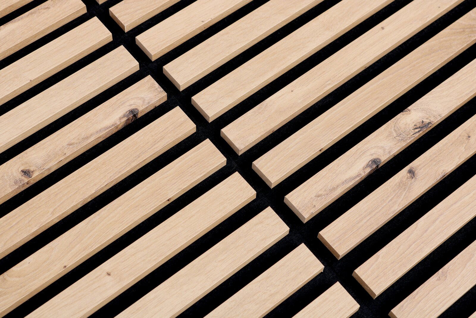 Nahaufnahme eines Dekopanels mit Holzlatten auf schwarzem Hintergrund, perspektivisch von oben fotografiert.