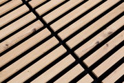 Nahaufnahme eines Dekopanels mit Holzlatten auf schwarzem Hintergrund, perspektivisch von oben fotografiert.