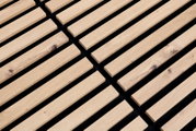 Nahaufnahme eines Dekopanels mit Holzlatten auf schwarzem Hintergrund, perspektivisch von oben fotografiert.