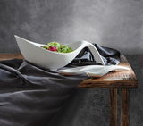 Elegantes Schalen-Set Flow 3-tlg. aus weißem Porzellan, präsentiert auf einem Holztisch mit dunklem Stoff, seitliche Perspektive.