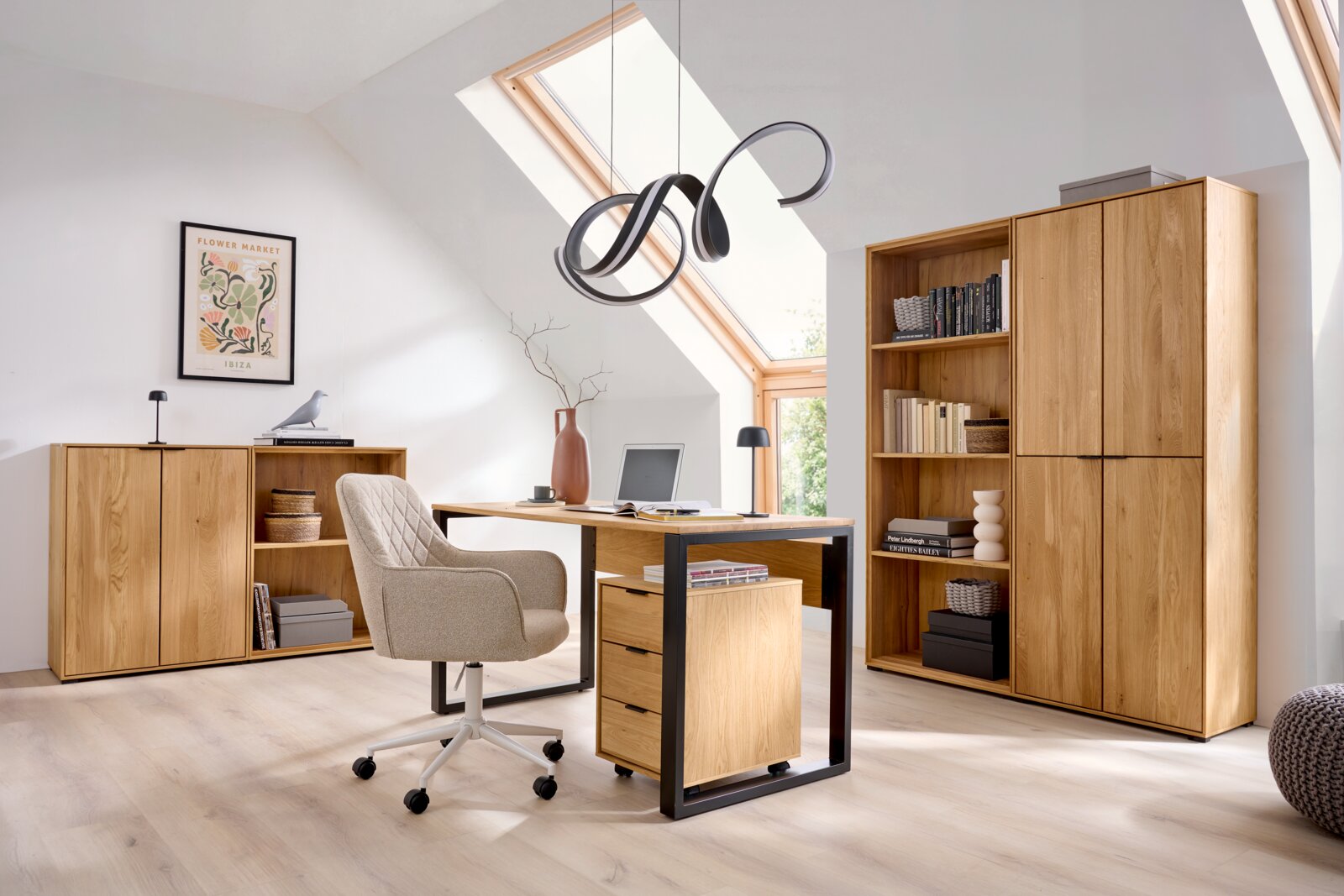 Modernes Homeoffice mit Holzschreibtisch und Rollcontainer im Vordergrund, gepolsterter Drehstuhl, Holzschrank und Sideboard im Hintergrund; Aufnahme aus leicht erhöhter, frontaler Perspektive.