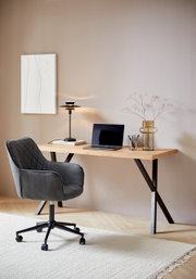 Moderner Schreibtisch mit Holzplatte und schwarzen Metallbeinen, seitliche Perspektive, dekoriert mit Laptop, Lampe und Vase.
