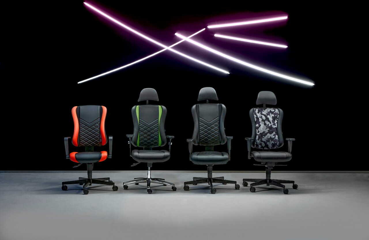 Vier Gaming-Stühle in verschiedenen Designs, von vorne betrachtet, vor einem dunklen Hintergrund mit leuchtenden Linien.