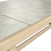 Nahaufnahme eines Garten-Esstisches mit heller Holzstruktur und grauer Steinplatte, Perspektive von oben.