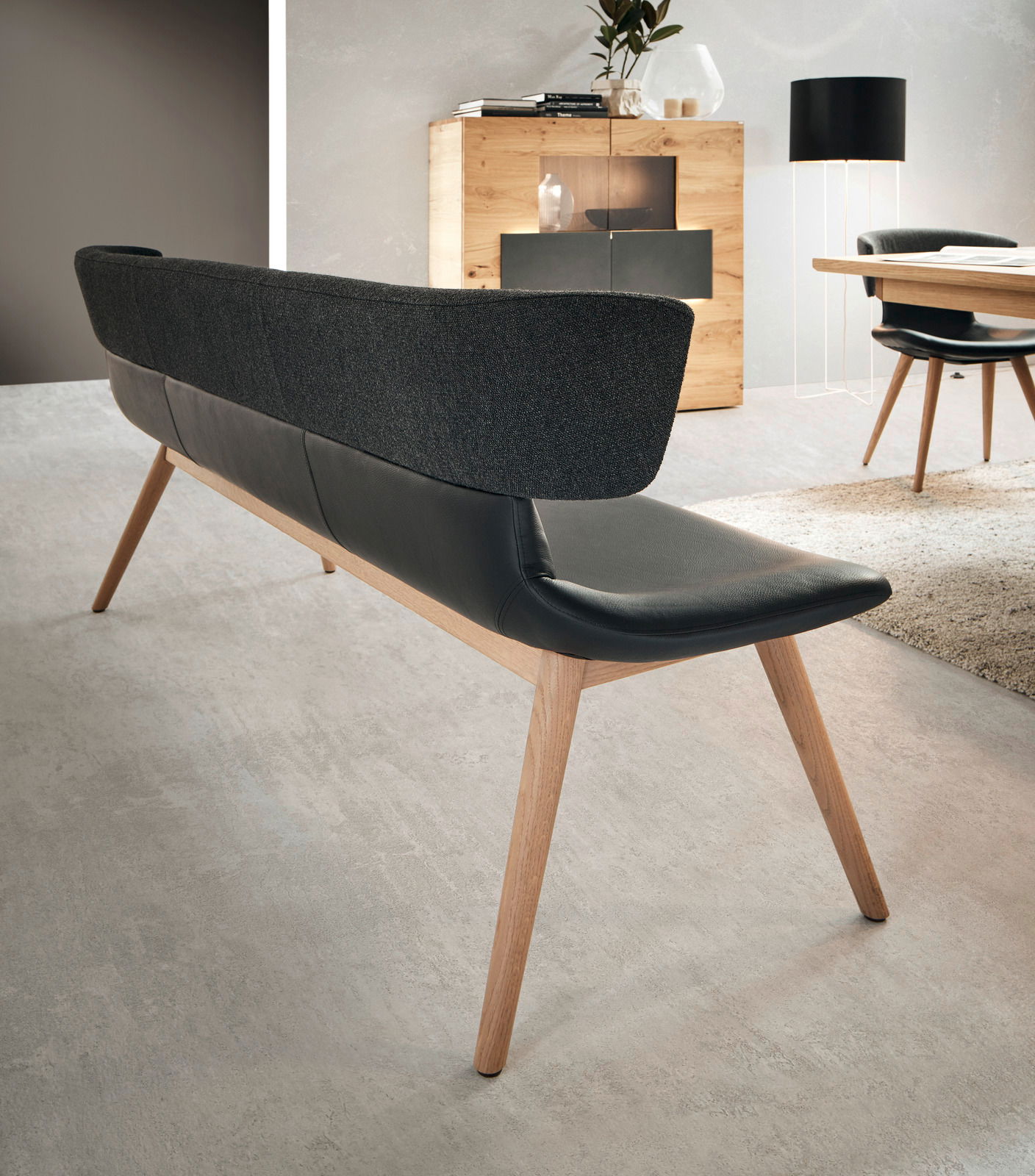 Moderne Bank mit schwarzer Polsterung und Holzbeinen, Rückansicht