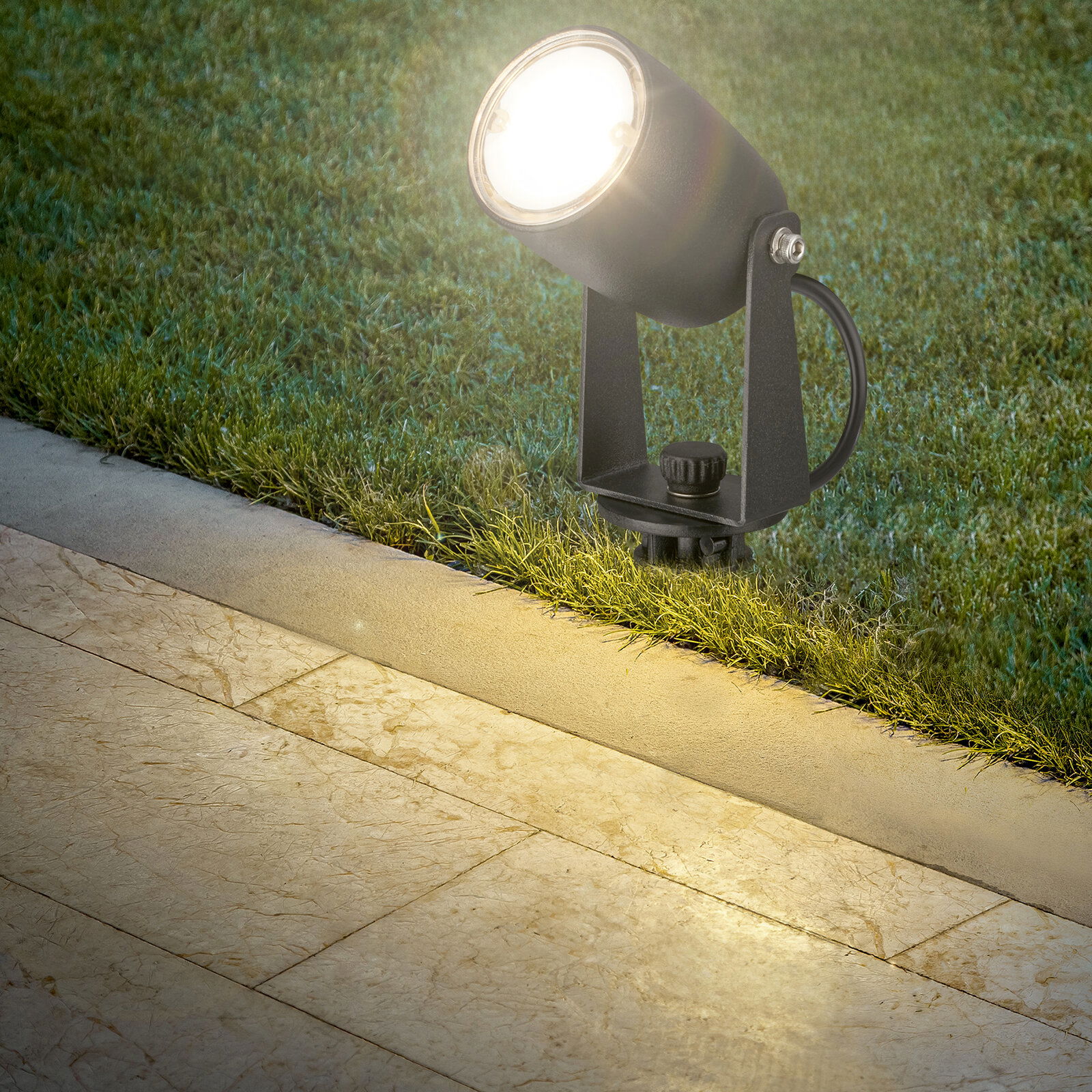 Bodenspot mit hellem Licht, installiert auf einer Rasenfläche neben einer Steinplatte, seitliche Perspektive
