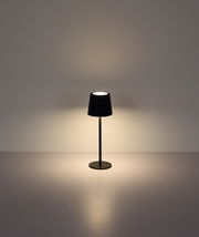 Moderne Tischleuchte in Schwarz, frontal fotografiert, mit sanftem Lichtschein auf einer glatten Oberfläche.