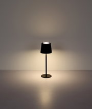 Moderne Tischleuchte in Schwarz, frontal fotografiert, mit sanftem Lichtschein auf einer glatten Oberfläche.