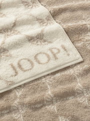 Beiges Gästetuch mit eingewebtem Muster und dem Schriftzug 'JOOP!' in Nahaufnahme.
