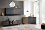 Moderne Wohnzimmermöbel in dunklem Design mit Holzakzenten, bestehend aus einem Sideboard, einem XL-Sideboard und einem TV-Lowboard, aus der Perspektive eines hellen, geräumigen Raumes mit großen Fenstern.