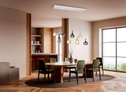 Moderne Mehrflammige Pendelleuchte mit weißem Baldachin und verschieden geformten Glas-Schirmen in Rauchgrau und Klar, warm leuchtend über einem Esstisch im Wohn-/Essbereich, Perspektive: frontale leicht seitliche Raumansicht von unten