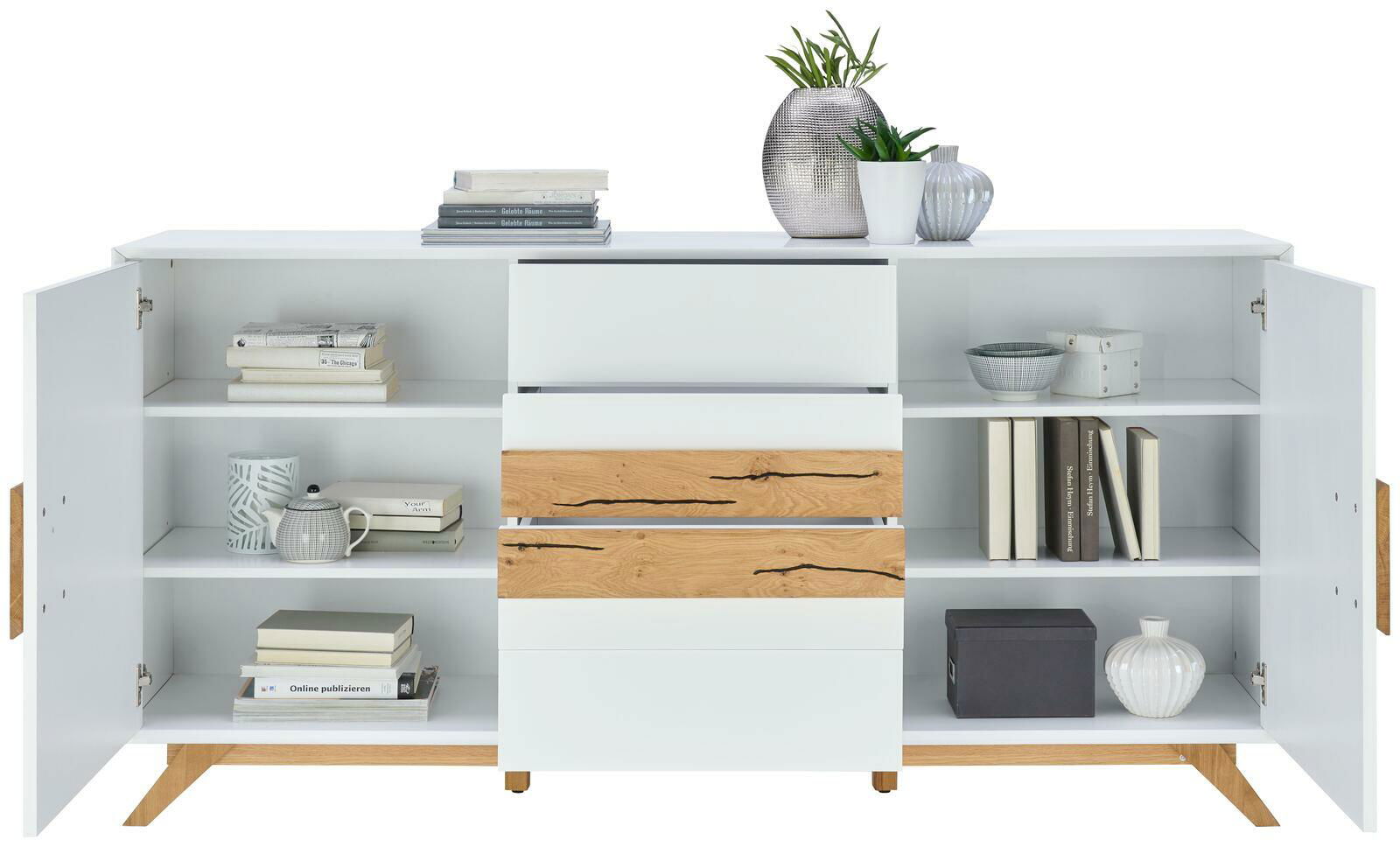 Modernes Sideboard in Weiß mit Holzakzenten, offene Türen und Schubladen, dekoriert mit Büchern und Pflanzen, frontale Ansicht.