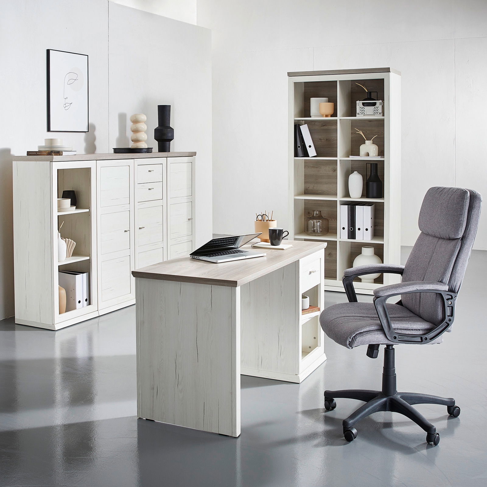 Moderner Schreibtisch in heller Holzoptik, frontal fotografiert, umgeben von passenden Regalen und einem ergonomischen Bürostuhl.