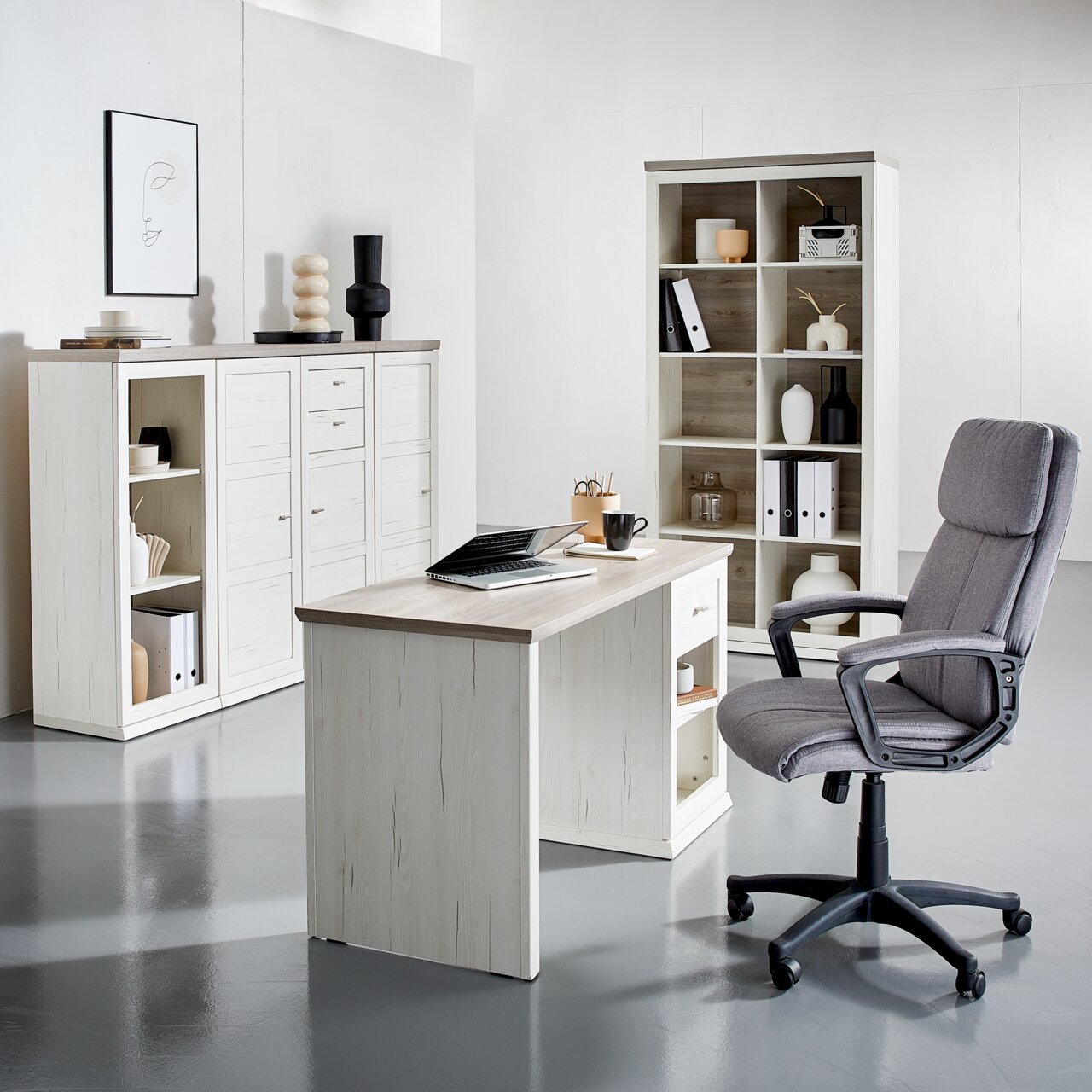 Modern bureau in lichte houtlook, van voren gefotografeerd, omringd door bijpassende planken en een ergonomische bureaustoel.