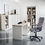 Modern bureau in lichte houtlook, van voren gefotografeerd, omringd door bijpassende planken en een ergonomische bureaustoel.