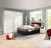 Moderner, weißer Schwebetürenschrank mit zwei Türen in einem hellen Schlafzimmer, seitliche Perspektive.