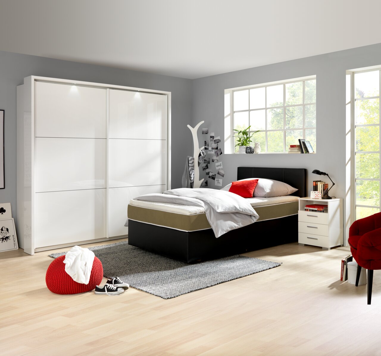 Moderner, weißer Schwebetürenschrank mit zwei Türen in einem hellen Schlafzimmer, seitliche Perspektive.