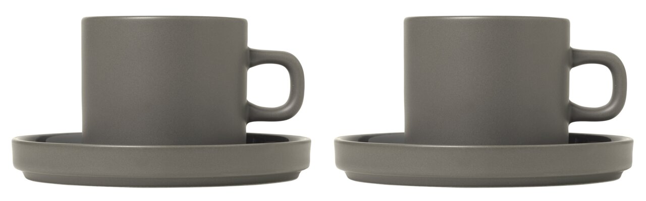 Twee grijze koffiekopjes met schoteltjes, van voren gefotografeerd.