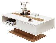 Moderner Couchtisch in Weiß mit Holzdetails, dekoriert mit Büchern, einer Tasse und Kerzen, seitliche Perspektive.