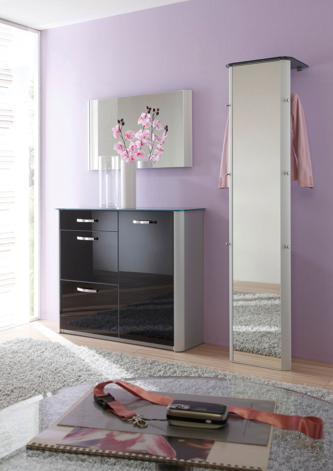 Moderne Garderobe mit Spiegel und Schrank in einem stilvollen Raum mit lila Wand, aus der Perspektive von vorne betrachtet.