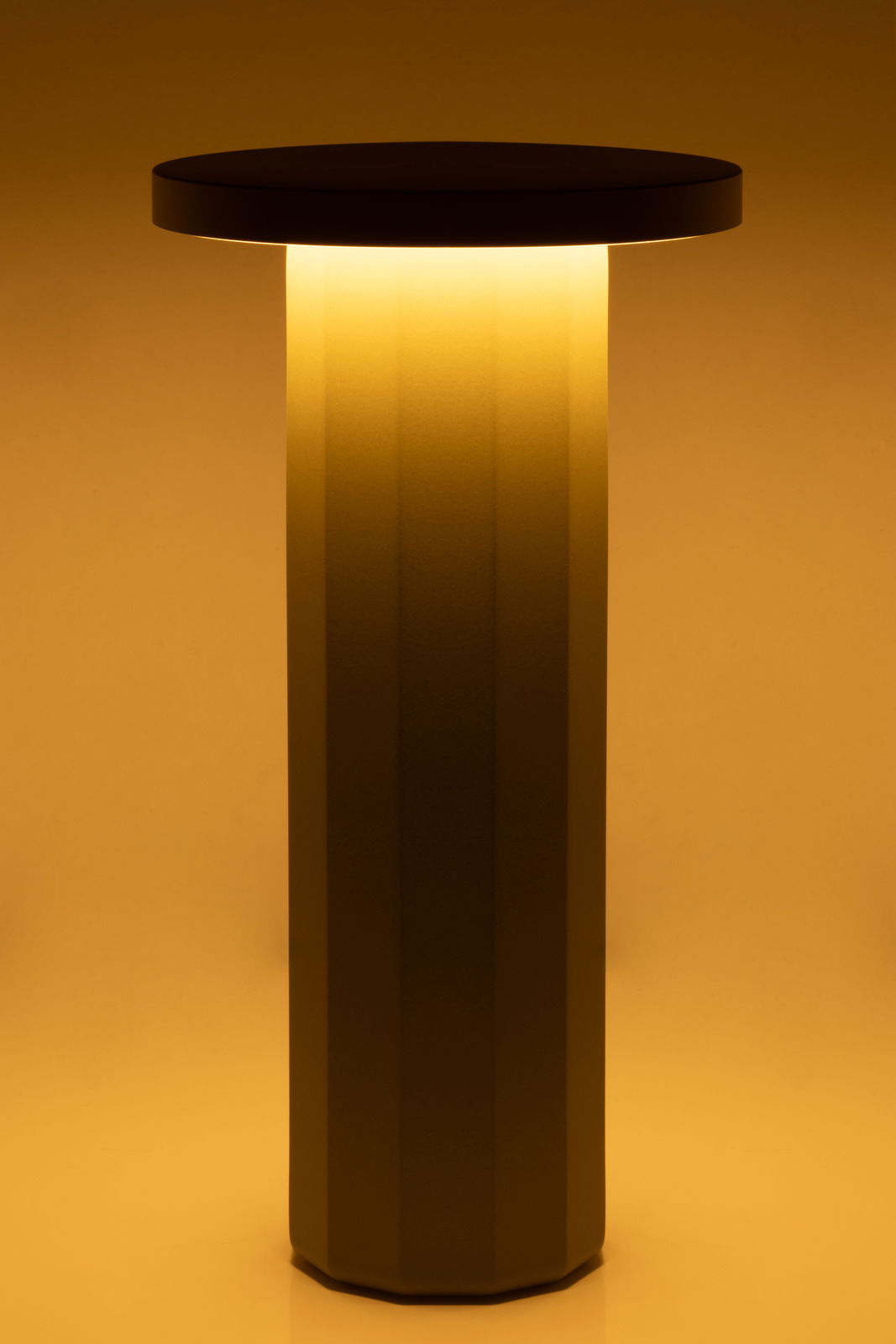 Moderne Akku-Tischleuchte mit zylindrischem Sockel und rundem Schirm, warmes Licht, seitliche Perspektive