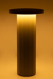 Moderne Akku-Tischleuchte mit zylindrischem Sockel und rundem Schirm, warmes Licht, seitliche Perspektive