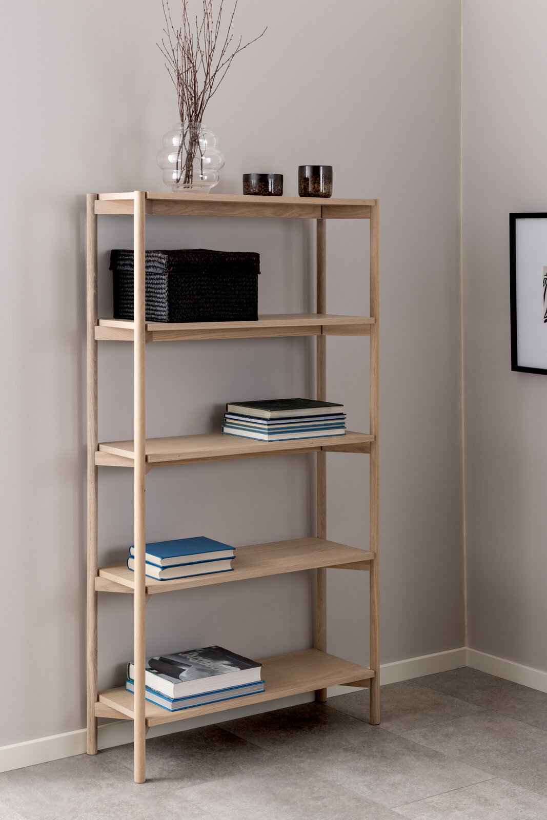 Holzregal mit fünf Ebenen, dekoriert mit Büchern, Körben und Vasen, in einer Ecke eines Raumes, seitliche Perspektive