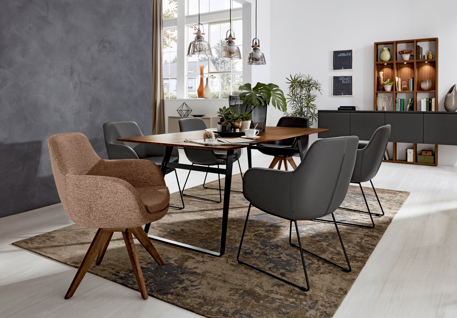 Esszimmer mit modernem Armlehnstuhl in Vorderansicht, umgeben von weiteren Stühlen und einem Holztisch, mit dekorativen Elementen im Hintergrund.