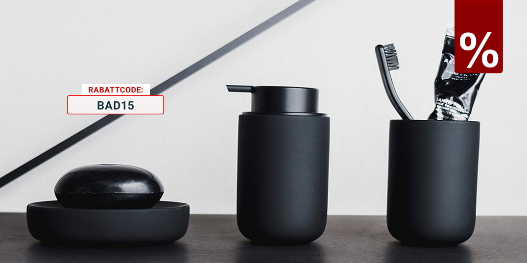 Stilvolle Badezimmeraccessoires in Schwarz: Seifenspender, Zahnputzbecher und Seifenschale auf Ablage