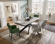 Moderner Esstisch mit grauer Tischplatte und schwarzen Beinen, umgeben von stilvollen Stühlen in einem hellen, eleganten Raum mit großen Fenstern. Perspektive von schräg oben.