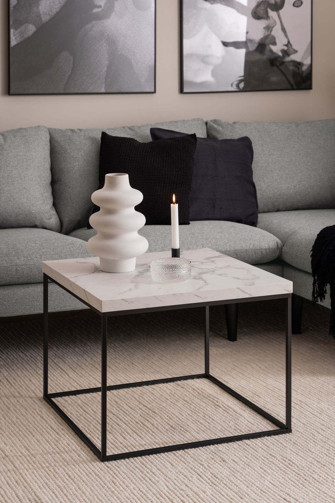 Moderner Couchtisch mit Marmoroptik und schwarzem Metallgestell, seitliche Perspektive