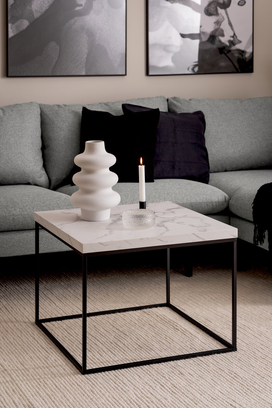 Moderner Couchtisch mit Marmoroptik und schwarzem Metallgestell, seitliche Perspektive