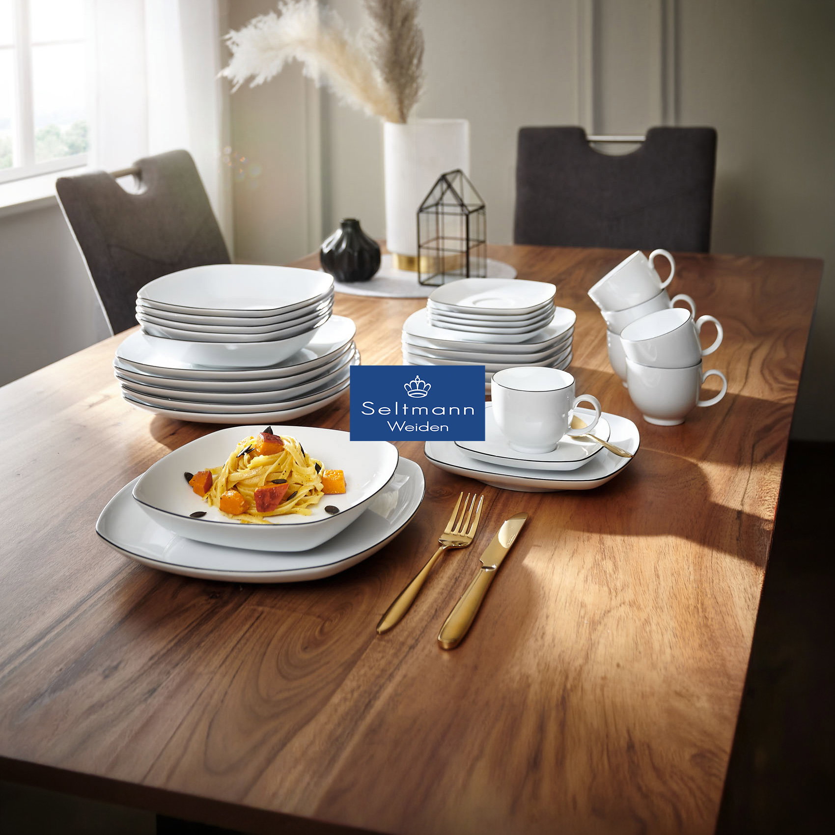 Modern gedeckter Esstisch mit weißem Geschirr, Tassen und goldbesteck, dekoriert, Pasta angerichtet, Seltmann Weiden Logo