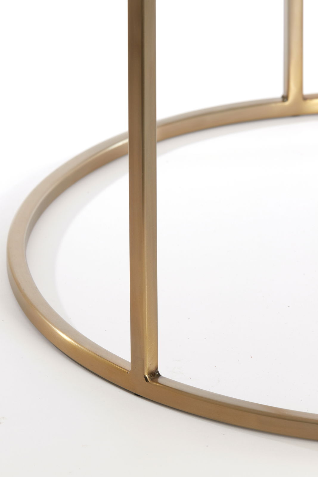 Nahaufnahme eines goldenen Metallrahmens eines Couchtisches aus der Seitenperspektive.
