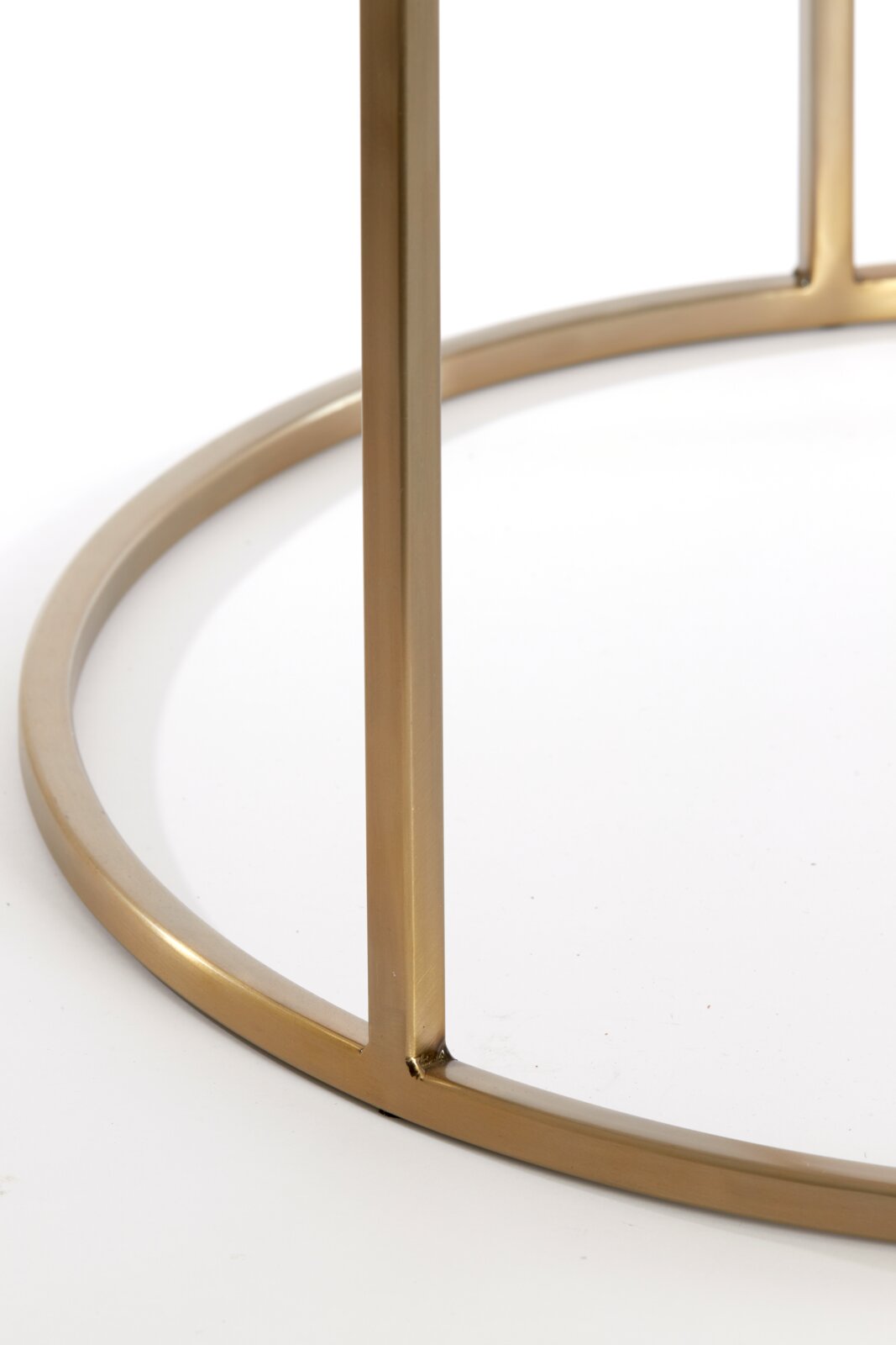 Nahaufnahme eines goldenen Metallrahmens eines Couchtisches aus der Seitenperspektive.