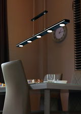 Moderne LED-Pendelleuchte über einem Esstisch, seitliche Perspektive