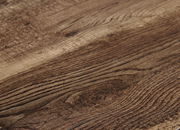Nahaufnahme einer Holzoberfläche mit natürlicher Maserung, perspektivisch von der Seite aufgenommen.