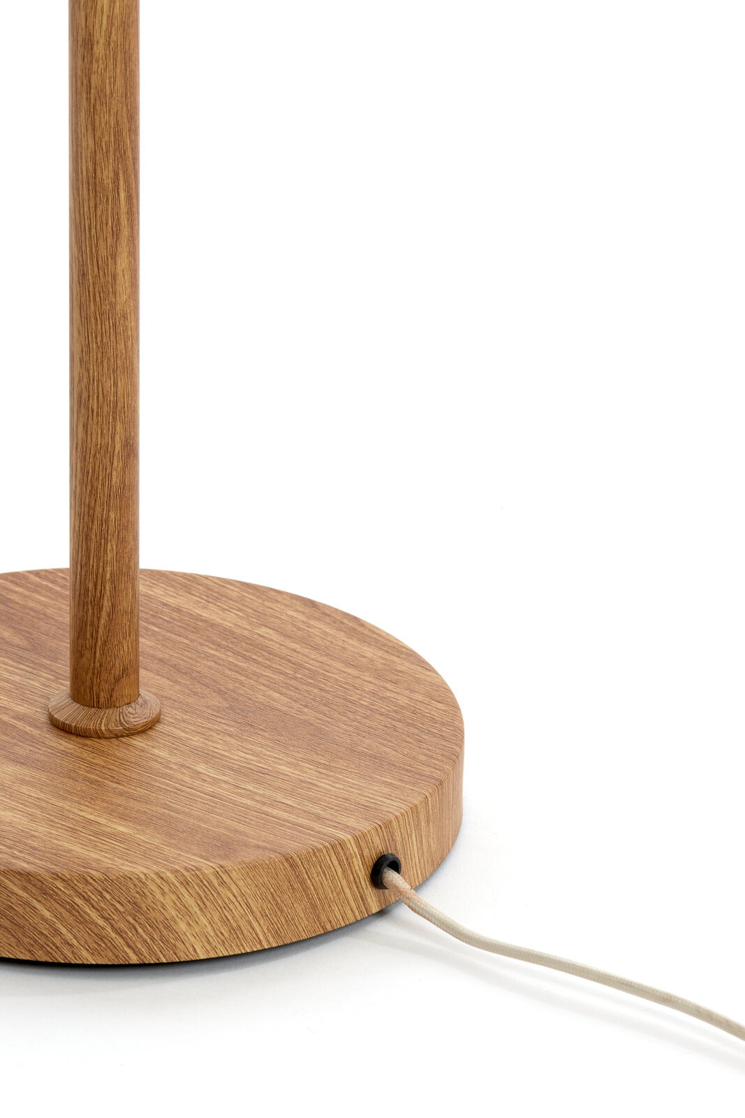Nahaufnahme des runden Holzsockels einer Tischlampe mit senkrechtem Holzstab und seitlich austretendem Textilkabel, Ansicht schräg von vorne
