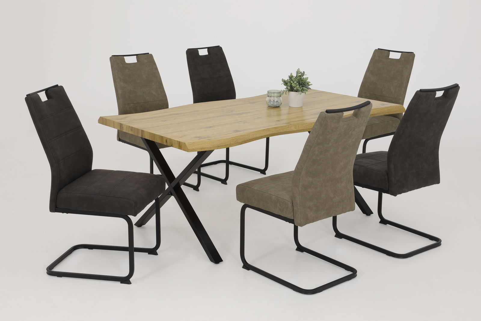 Esszimmer mit sechs Schwingstühlen in verschiedenen Farben um einen Holztisch, seitliche Perspektive