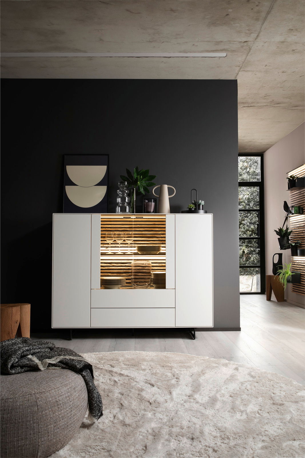 Modernes Highboard in einem stilvollen Wohnzimmer, frontal betrachtet, mit dekorativer Beleuchtung und Pflanzen.