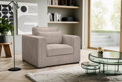Beiger, gepolsterter Cord-Sessel mit breiten Armlehnen und Rückenkissen im modernen Wohnzimmer neben Glas-Couchtisch und Fensterfront, Perspektive: leicht schräg von vorne links.