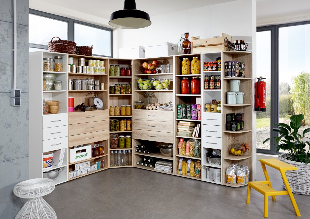 Eckschranklösung in einer modernen Küche, gefüllt mit Vorratsgläsern, Dosen und Küchenutensilien, aus der Perspektive von vorne links.