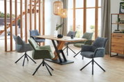 Esszimmer mit modernem Holztisch und sechs gepolsterten Sesseln in verschiedenen Farben, seitliche Perspektive