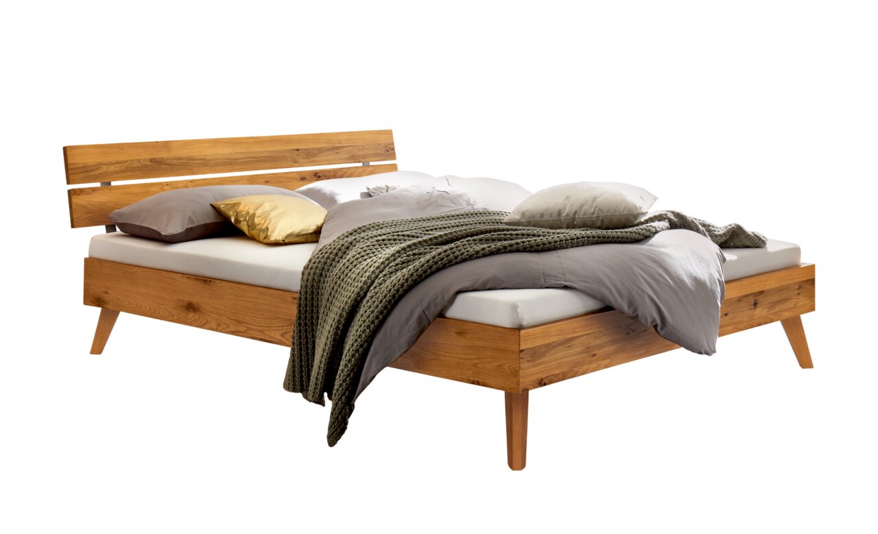 Holzbett mit Kopfteil aus Holz und Metall, seitliche Perspektive, dekoriert mit Kissen und Decke