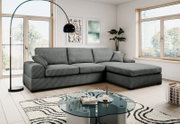 Modernes graues Ecksofa mit rechter Ottomane in hellem Wohnzimmer, frontale leicht schräge Perspektive