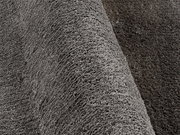 Nahaufnahme eines grauen Hochflor-Teppichs mit weicher, flauschiger Textur, seitliche Perspektive