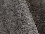 Nahaufnahme eines grauen Hochflor-Teppichs mit weicher, flauschiger Textur, seitliche Perspektive
